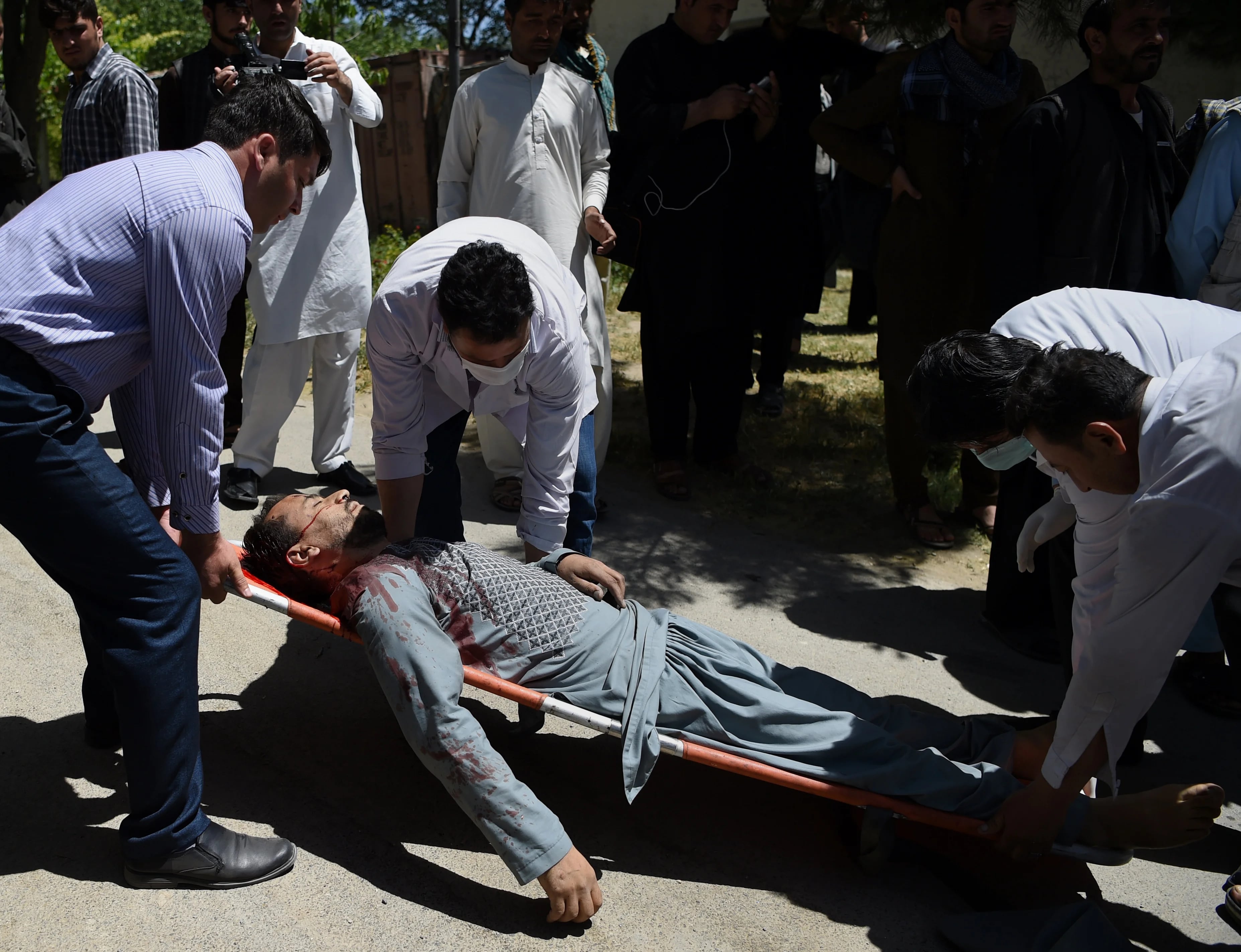 Voluntarios llevan el cuerpo de uno de los muertos en el ataque terrorista (AFP)