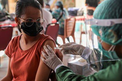 Una mujer recibe una dosis de la vacuna contra la enfermedad del coronavirus (COVID-19) de AstraZeneca durante un programa de vacunación masiva para la Zona Verde de Turismo en Sanur, Bali, Indonesia, el 23 de marzo de 2021. REUTERS