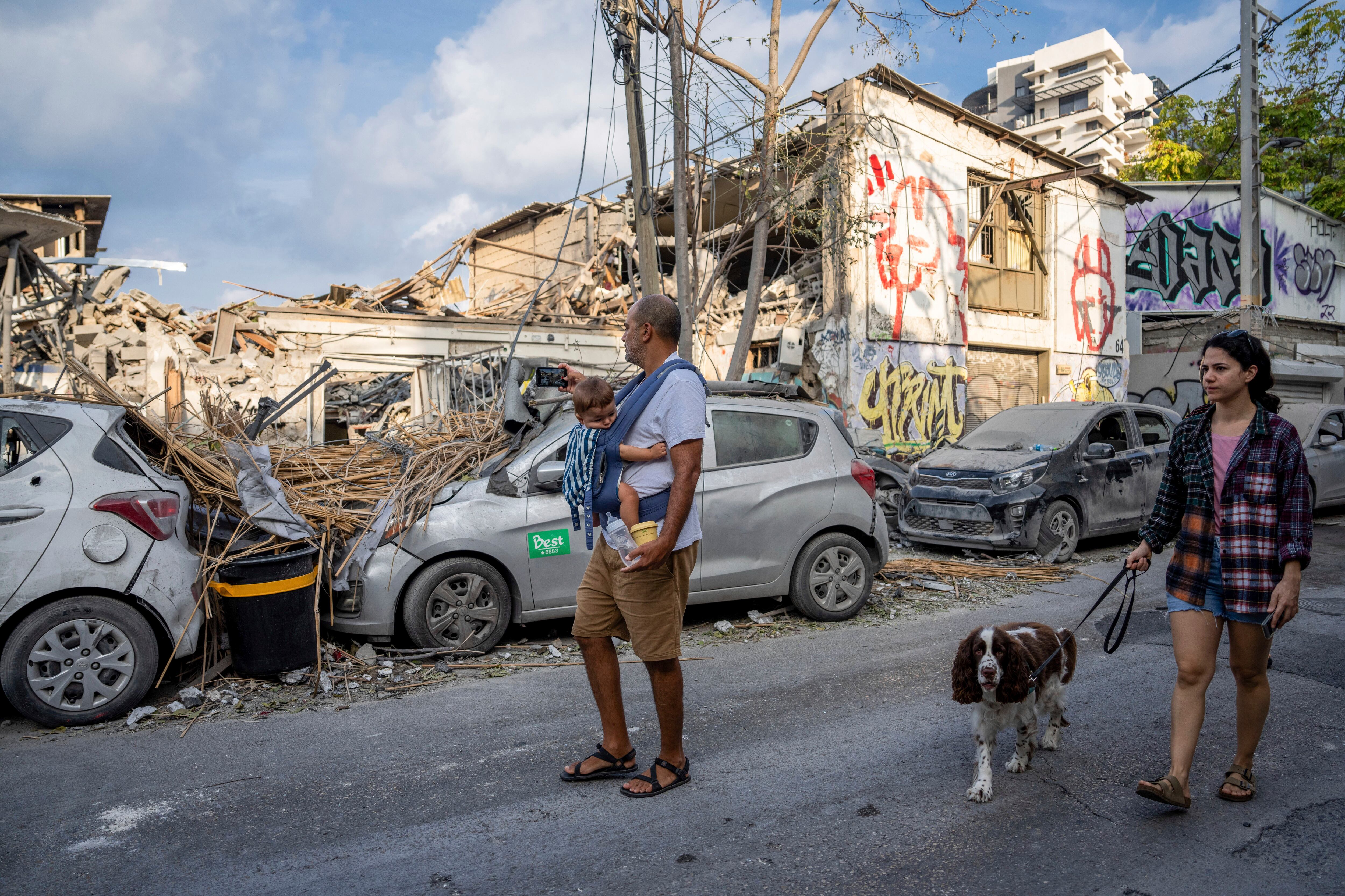 Israelíes inspeccionan los escombros de un edificio un día después de que fuera alcanzado por un cohete disparado desde la Franja de Gaza, en Tel Aviv (AP/Oded Balilty)