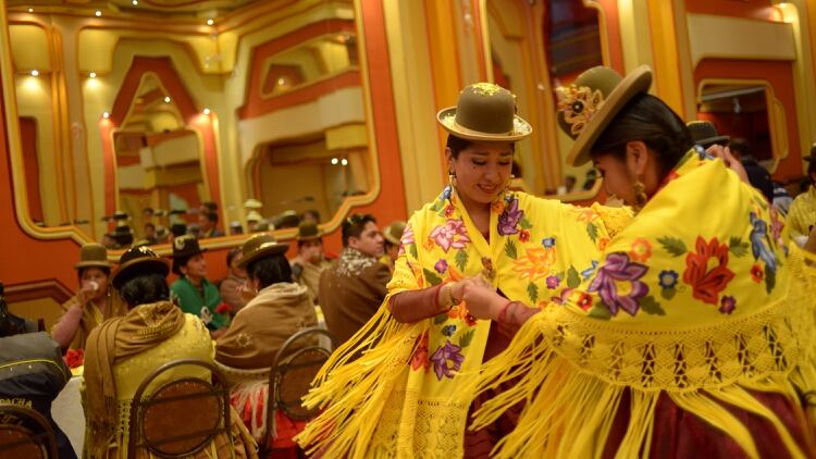 Dos mujeres aymaras bailan con su vestimenta típica (REUTERS)