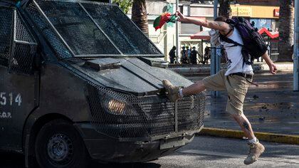 Un manifestante pegando una patada a un camión de la Policía (MARTIN BERNETTI / AFP)