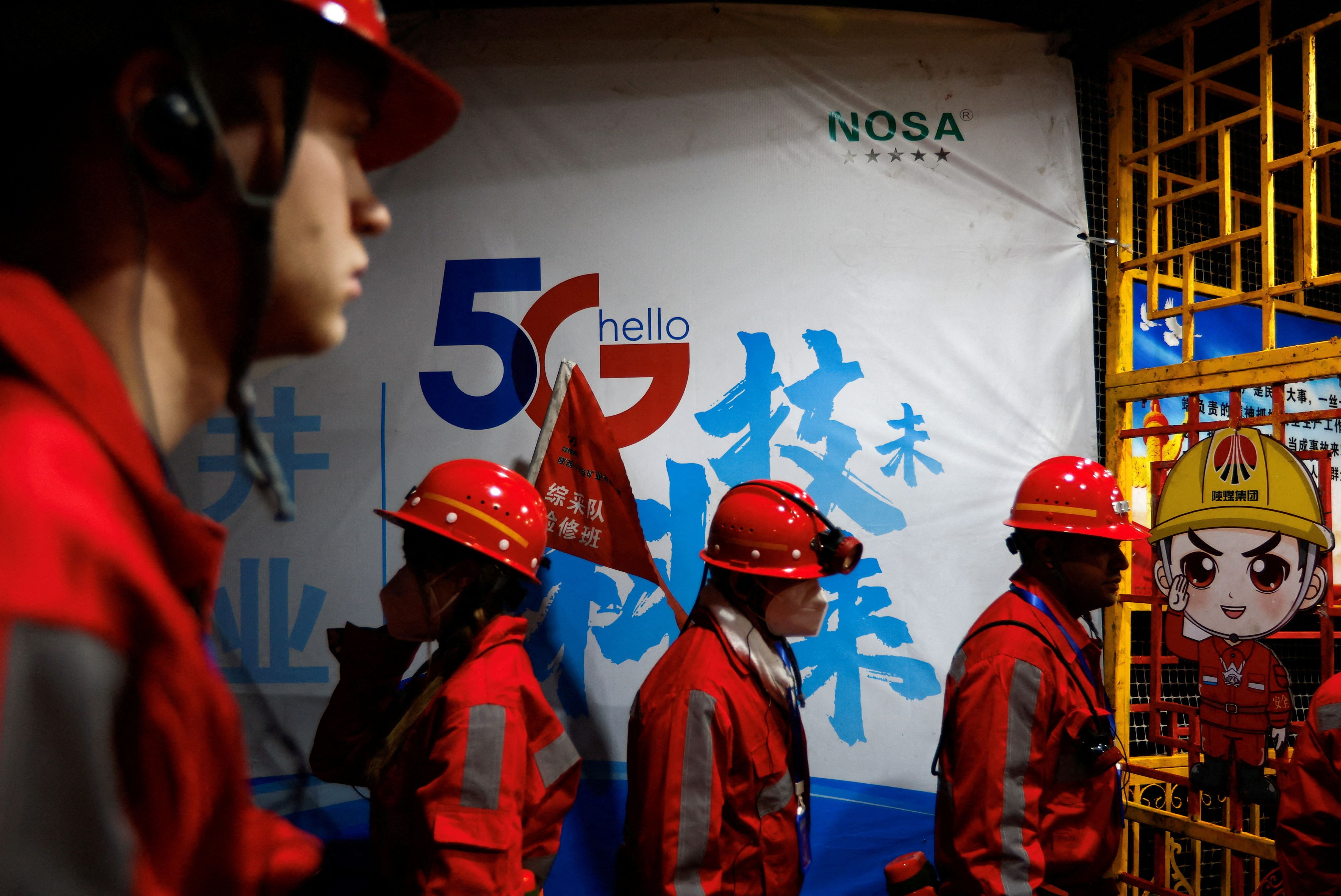 Reporteros de los medios pasan junto a un letrero de 5G en una superficie de carbón subterránea donde se implementan las estaciones base 5G de Huawei. REUTERS/Tingshu Wang/Foto de archivo
