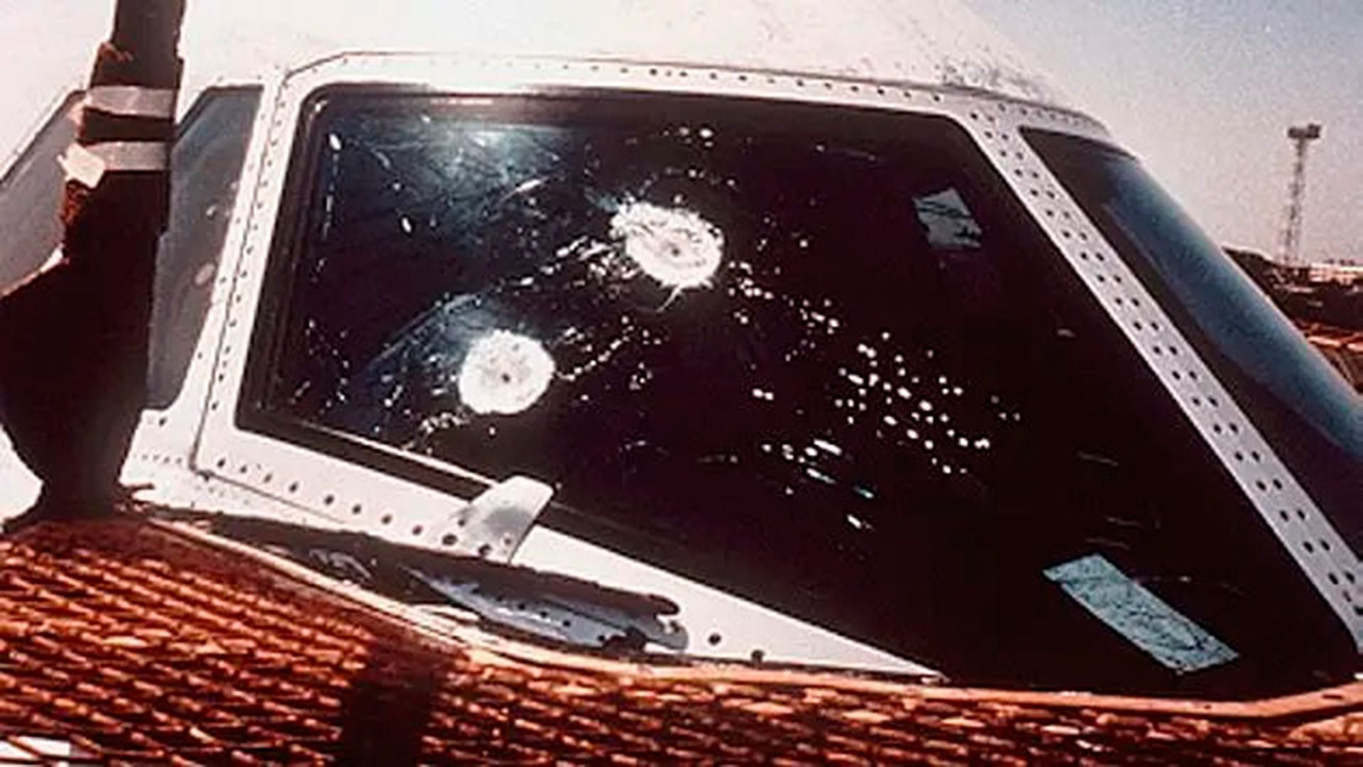Una foto del parabrisas del avión con agujeros de bala