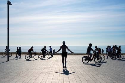 La gente se ejercita en la acera de la playa de la Barceloneta, durante las horas en las que se permite el ejercicio individual al aire libre en Barcelona, España, el 22 de mayo de 2020 (REUTERS/Nacho Doce)