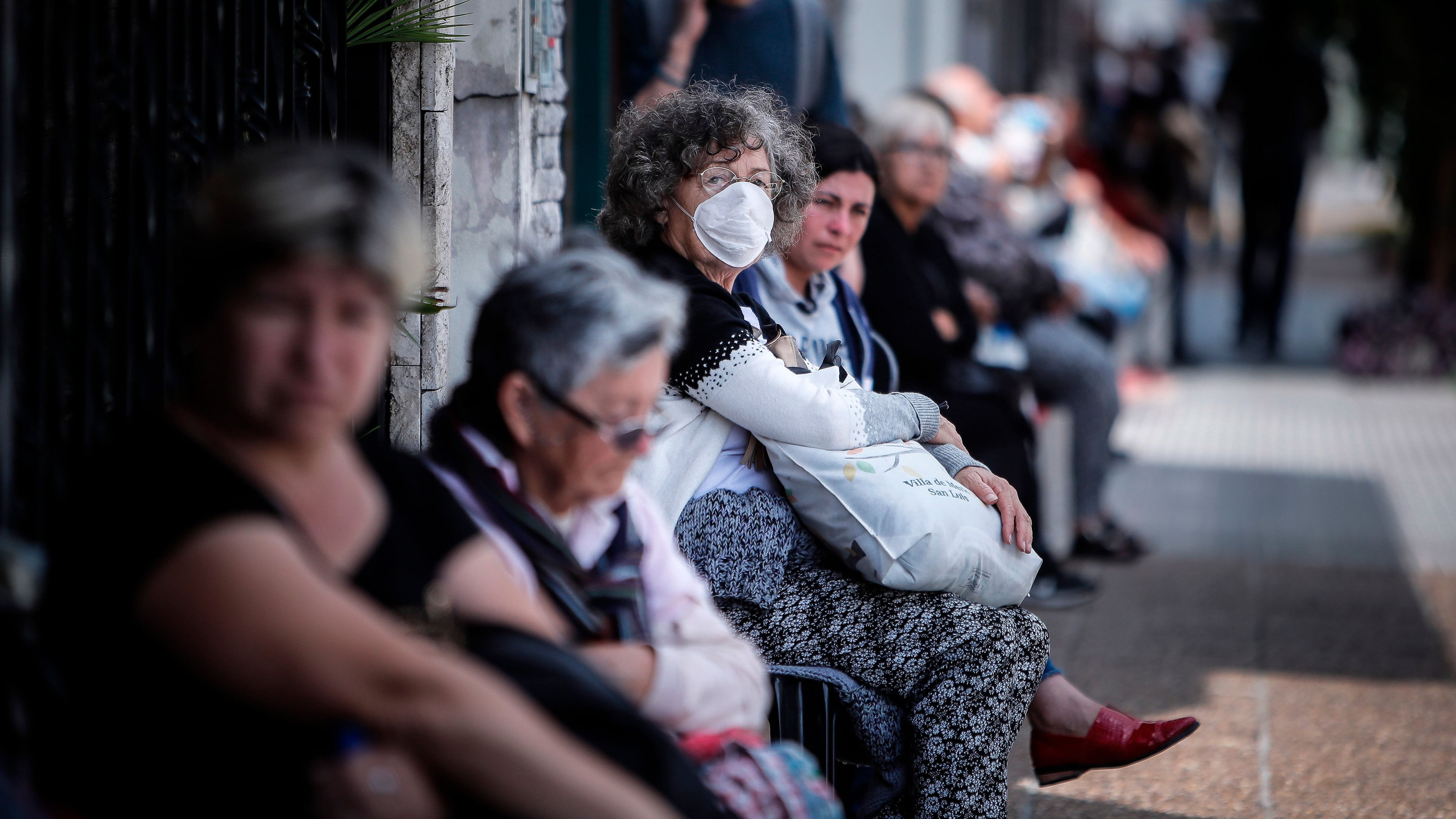 Personas que hacen fila afuera de un banco donde pagan jubilaciones. EFE/Juan Ignacio Roncoroni 