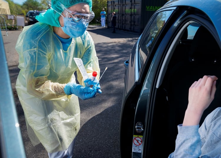 Una trabajadora médica se prepara para tomar una muestra de un joven en un centro de pruebas de coronavirus en Holbaek, Dinamarca, el 21 de abril de 2020. (Ritzau Scanpix/Claus Bech vía REUTERS)