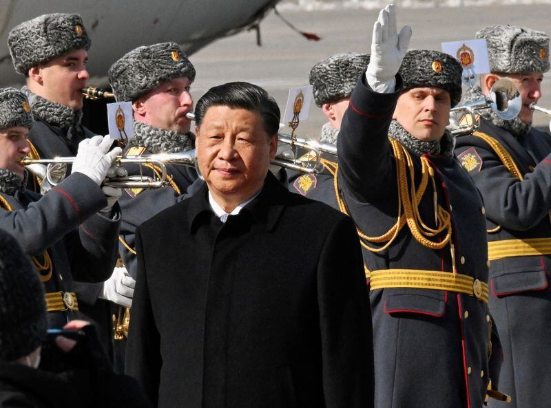 El presidente chino, Xi Jinping, camina junto a guardias de honor y miembros de una banda militar durante una ceremonia de bienvenida a su llegada a un aeropuerto en Moscú (Kommersant Photo/Anatoliy Zhdanov vía REUTERS/Archivo)
