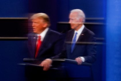 El presidente Donald Trump y el líder demócrata Joe Biden se ven reflejados en el plexiglás que protege del coronavirus a un operador de cámara de televisión cuando participan en el segundo debate de la campaña presidencial de EEUU el 22 de octubre de 2020 (REUTERS/Mike Segar)