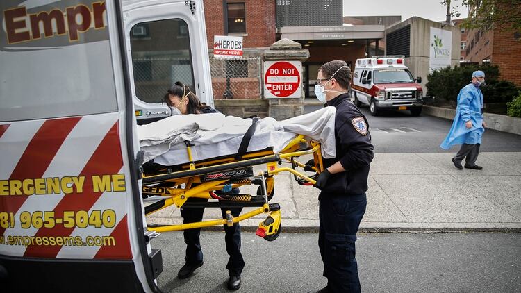 Los técnicos médicos de emergencia cargan a un paciente en una ambulancia mientras el Dr. Anthony Leno, Director de Medicina de Emergencia, se encuentra afuera al final de su turno (AP/John Minchillo)