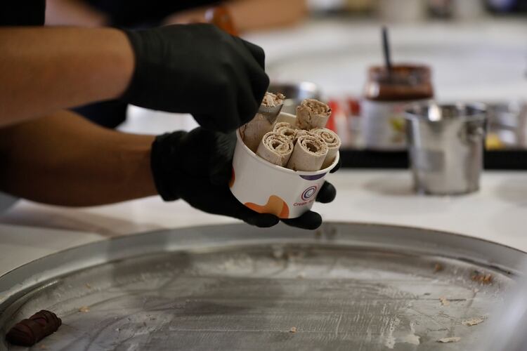 A punto de terminar el helado. El roller poniendo los rolls en el pote, el paso previo a colocar la salsa y los toppings 