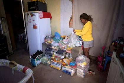 Celia, madre de Miguel Barros, de 11 años, junto a las donaciones de alimentos que recibió