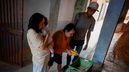 Bryan Blanco, de 27 años, cambia plátanos por arroz en un callejón de Catia (EFE/RAYNER PEÑA R)
