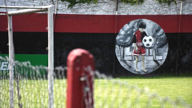 El mural con el Messi niño parece contemplar la canchita donde cientos de chicos pasan por allí soñando con ser Messi. (Leo Galletto)