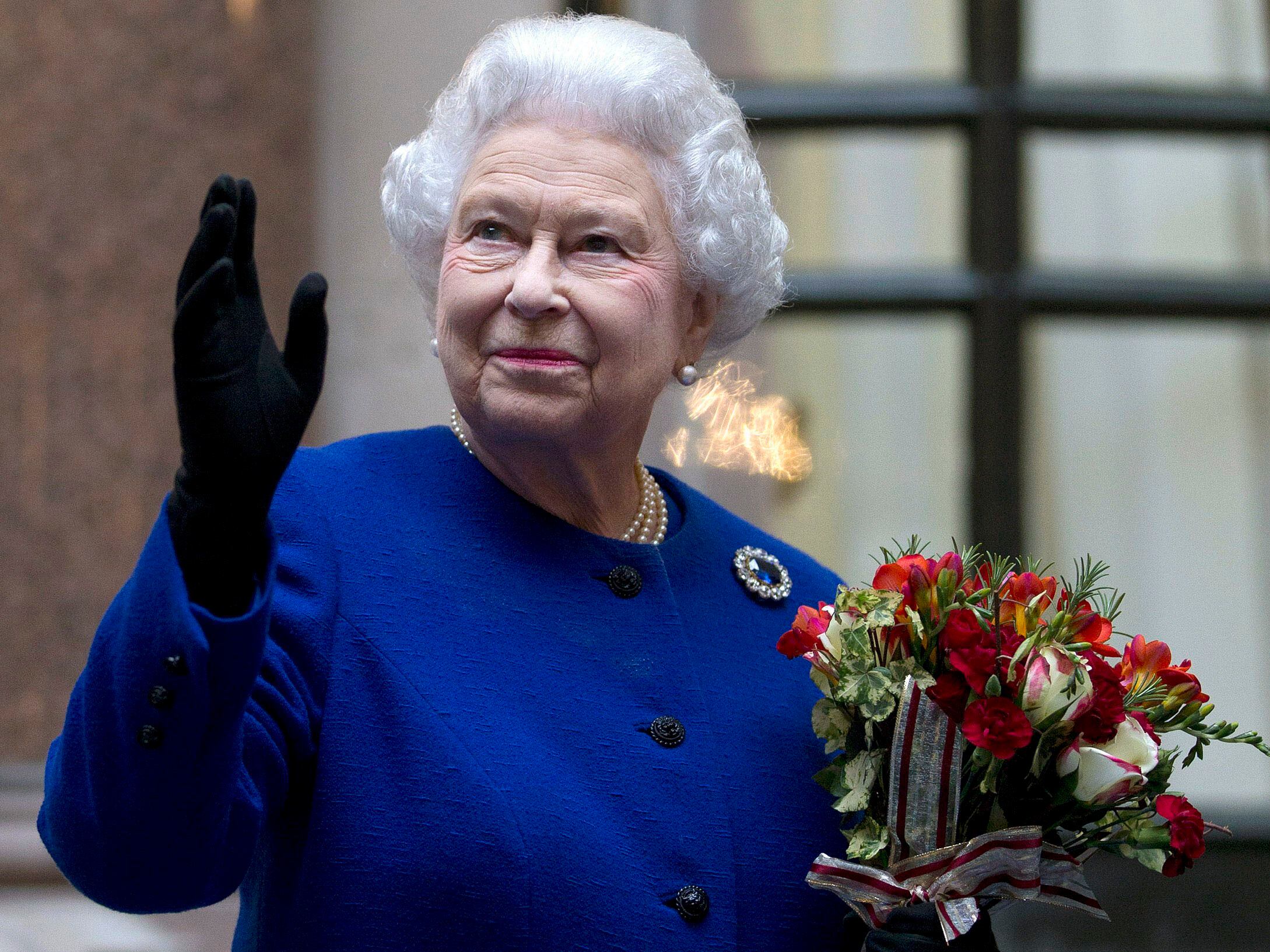 ARCHIVO - En imagen de archivo del martes 18 de diciembre de 2012, la reina Isabel II saluda a personal del Ministerio de Relaciones Exteriores y de la Mancomunidad de Naciones al final de una visita oficial en Londres. (AP Foto/Alastair Grant Pool, archivo)