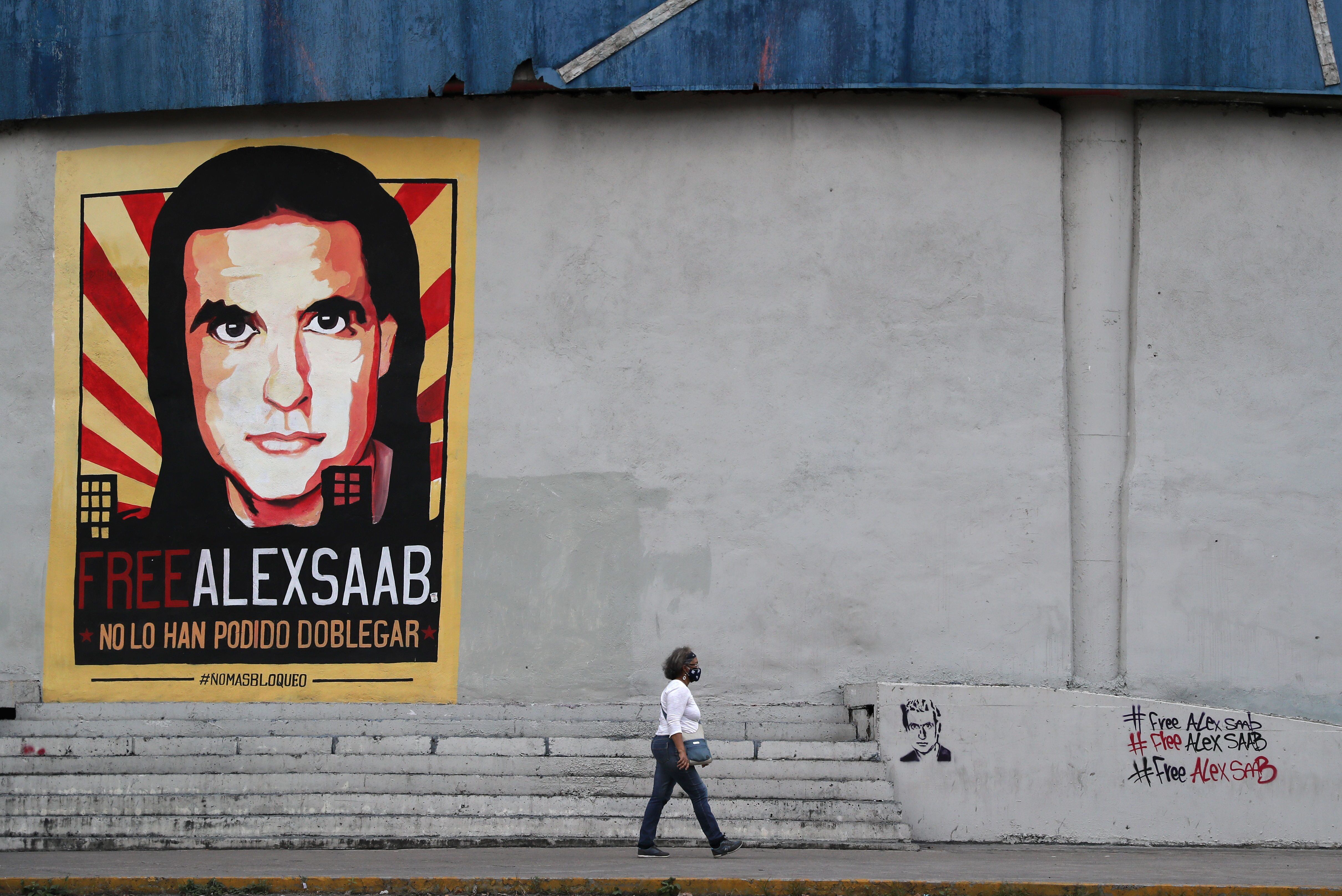 Una mujer pasa frente a un cartel de Alex Saab en Caracas 