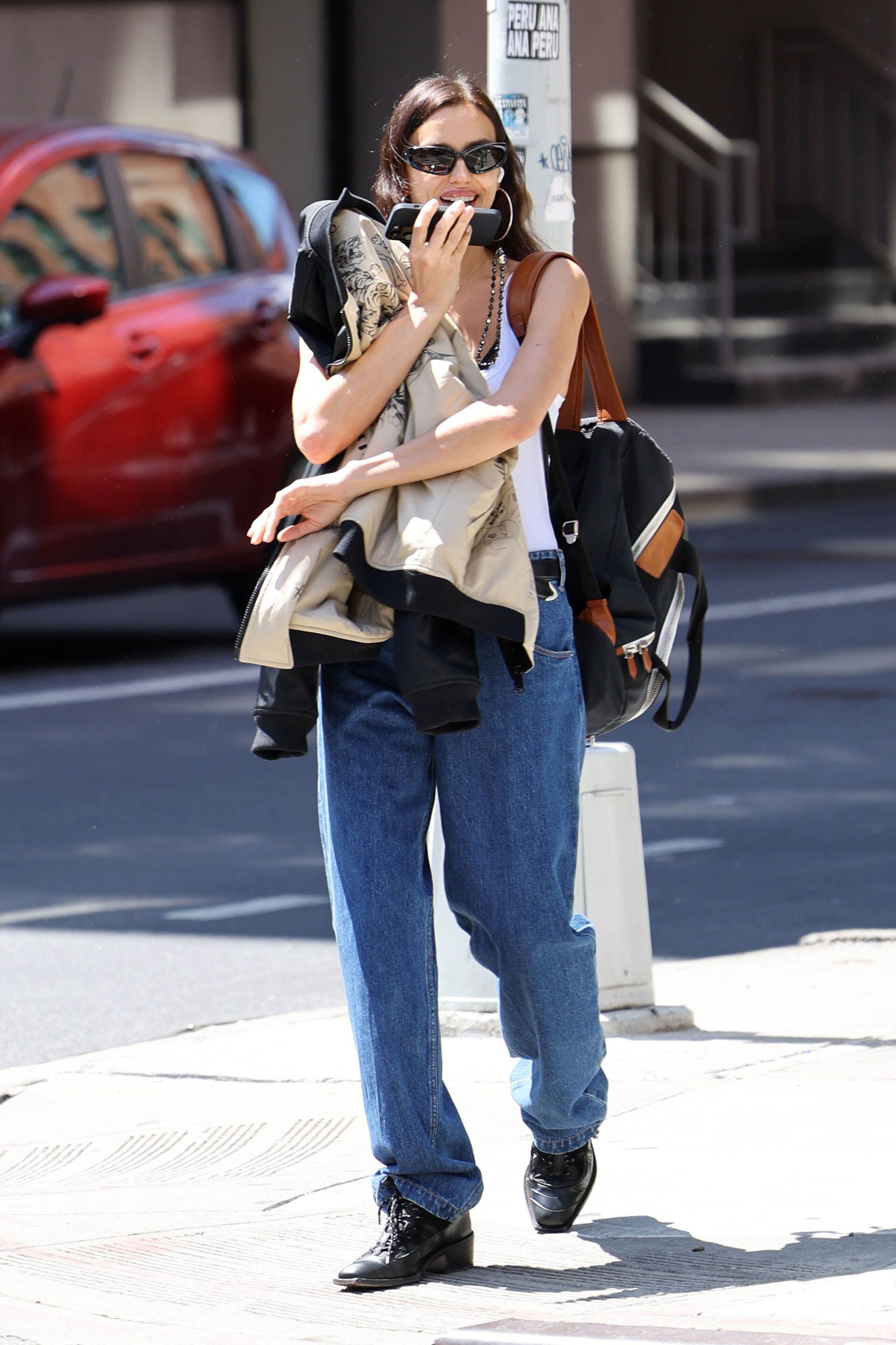 Irina Shayk compartió un almuerzo con una amiga en Nueva York. Para ello, lució un look casual trendy: musculosa blanca, pantalón de jean, borcegos estilo texanos con cordones, y cargó una campera negra y una mochila (The Grosby Group)