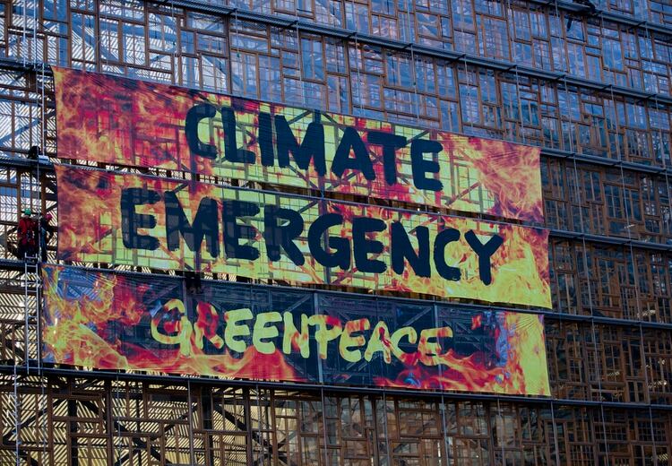 Activistas por el clima, desplegaron una pancarta en un andamio en el Edificio Europa durante una cumbre de la UE, en Bruselas, el 12 de diciembre de 2019. (AP Foto/Virginia Mayo)