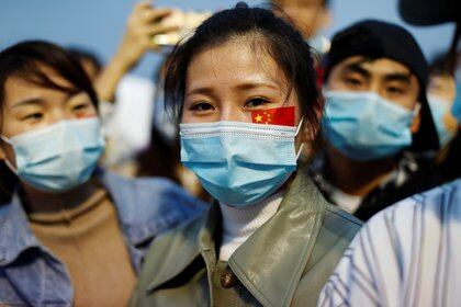 Jóvenes con máscaras faciales en China. REUTERS/Carlos Garcia Rawlins