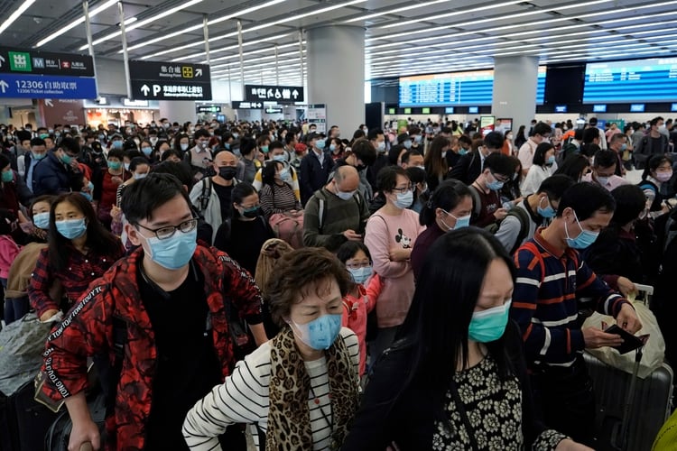 Pasajeros con cubrebocas en la sala de salidas de una estación de tren de alta velocidad en Hong Kong, el jueves 23 de enero de 2020. (AP Foto/Kin Cheung)