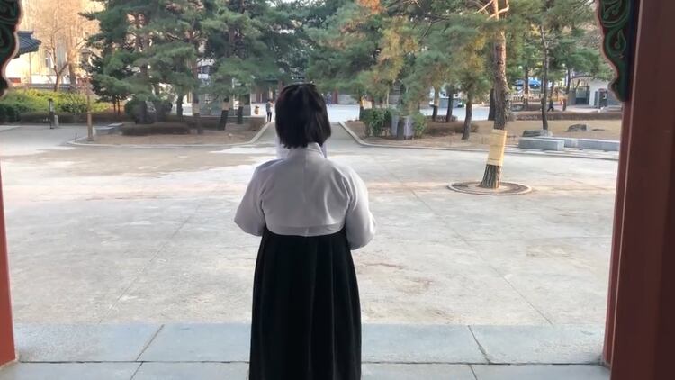 La mujer vestía un antiguo hanbok blanco y negro.