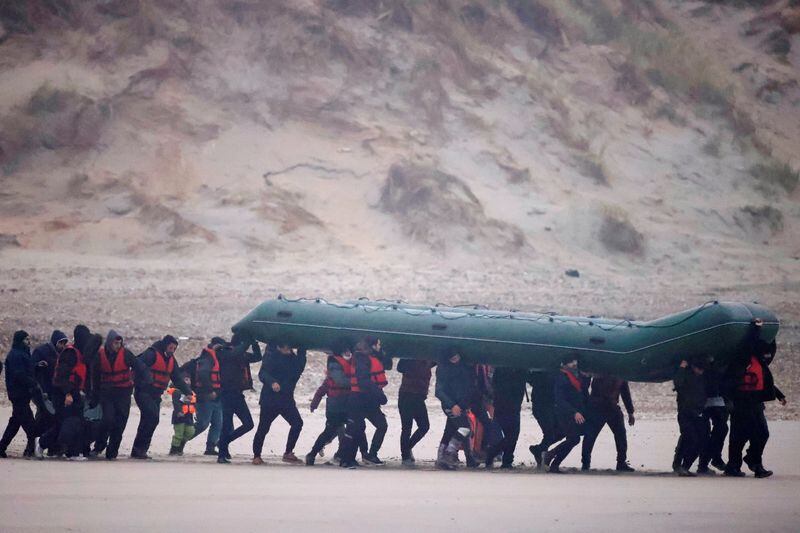 A group of more than 40 migrants race on the beach with an inflatable boat, leaving the coast of northern France and crossing the English Channel, near Wimereux, France.  November 24, 2021. REUTERS / Gonzalo Fuentes