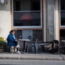 A woman sits with a glass of wine at a table outside a restaurant, as the spread of the novel coronavirus continues, in Stockholm, Sweden April 17, 2020. Stina Stjernkvist / TT News Agency/via REUTERS ATTENTION EDITORS - THIS IMAGE WAS PROVIDED BY A THIRD PARTY. SWEDEN OUT. NO COMMERCIAL OR EDITORIAL SALES IN SWEDEN.