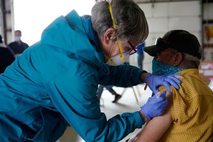 La enfermera registrada Pat Heinen le da a Genard Chávez su vacuna contra la enfermedad por coronavirus (COVID-19) en un sitio de vacunación rural en Columbus, Nuevo México, EE. UU., 16 de abril de 2021. (REUTERS / Paul Ratje)