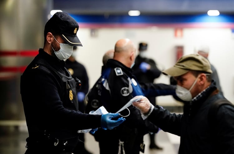 Un policía reparte mascarillas en Madrid (Reuters)
