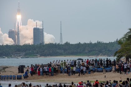 Sekelompok orang dari pantai menyaksikan peluncuran roket Long March-5B Y2 dari Pusat Peluncuran Luar Angkasa Wenchang di Provinsi Hainan pada 29 April 2021. China Daily via Reuters