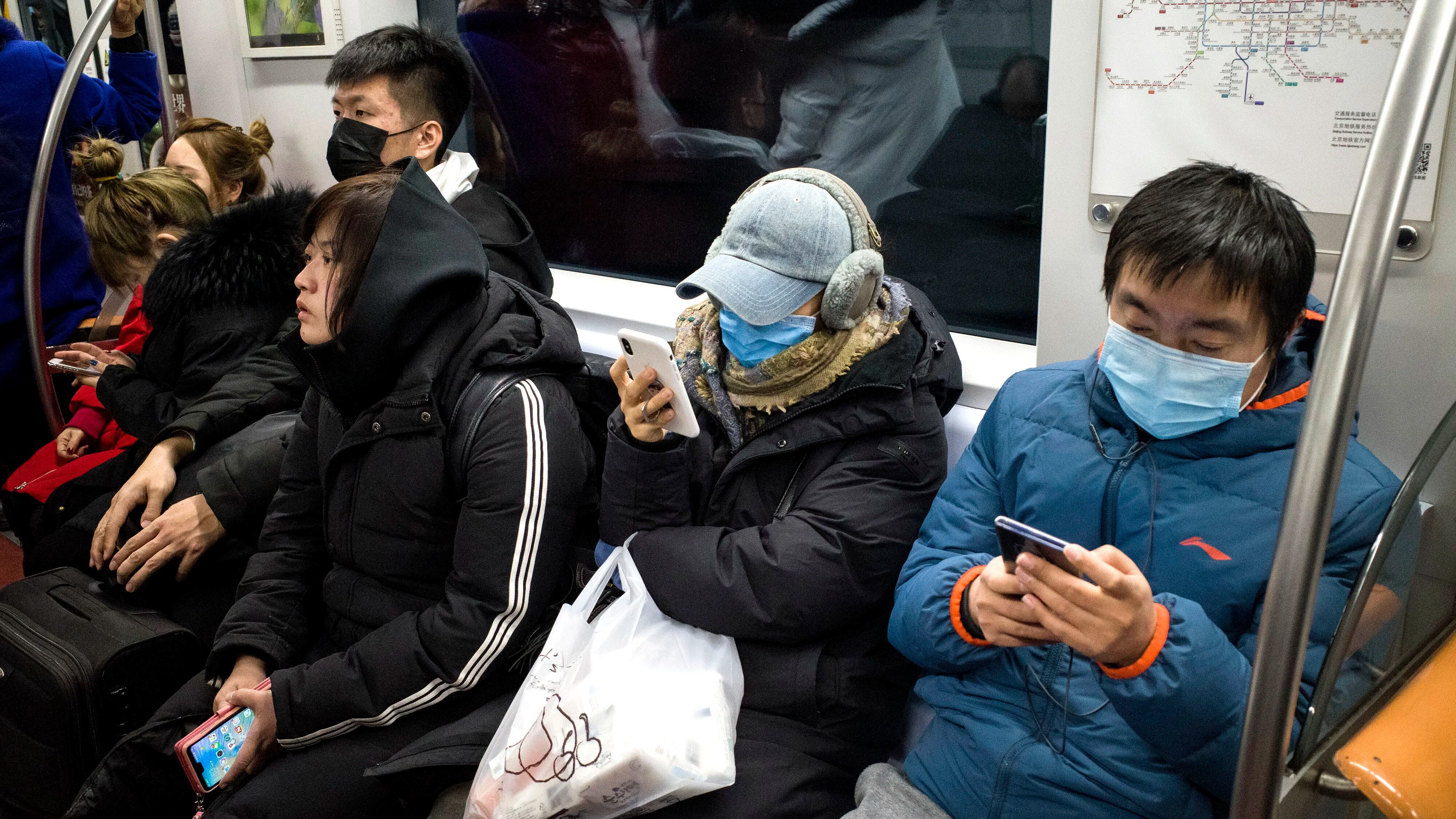 Los pasajeros del metro usan máscaras protectoras en Beijing el 21 de enero de 2020. - El número de muertos por un nuevo virus de China que es transmisible entre humanos aumentó a seis, dijo el alcalde de Wuhan en una entrevista con la cadena estatal CCTV el 21 de enero. La Organización de la Salud dijo que consideraría declarar una emergencia internacional de salud pública sobre el brote. (Foto por NOEL CELIS / AFP)