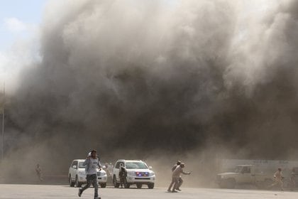 La gente en medio del polvo que se levanta después de que las explosiones golpearon el aeropuerto de Aden, a la llegada del recién formado gobierno yemení a Aden (REUTERS/Fawaz Salman)