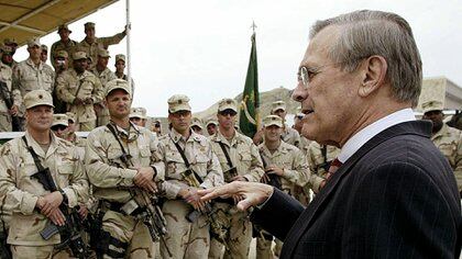 El secretario de Defensa de Estados Unidos, Donald Rumsfeld (izq.), Se reúne el 1 de mayo de 2003 con las tropas de las Fuerzas Especiales de Estados Unidos en la base estadounidense de Kabul. Rumsfeld declaró el fin de las operaciones de "combate mayor" y una nueva era de estabilidad y reconstrucción en Afganistán, 18 meses después de que las fuerzas lideradas por Estados Unidos derrocaran al régimen talibán. (AFP PHOTO / Luke FRAZZAL)