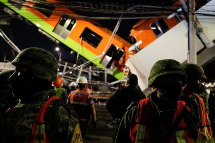 Los socorristas trabajan en el sitio donde un paso elevado de un metro colapsó parcialmente mientras pasaba el tren en la estación de Olivos, en la Ciudad de México, en la madrugada del 4 de mayo de 2021 (Reuters/ Luis Cortes)