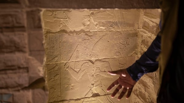 El arqueólogo Ragab Dawood describe una talla de piedra mientras realiza un recorrido por la pirámide escalonada en Saqqara, Egipto, que se abrió para los visitantes el jueves 5 de marzo de 2020 (AP)