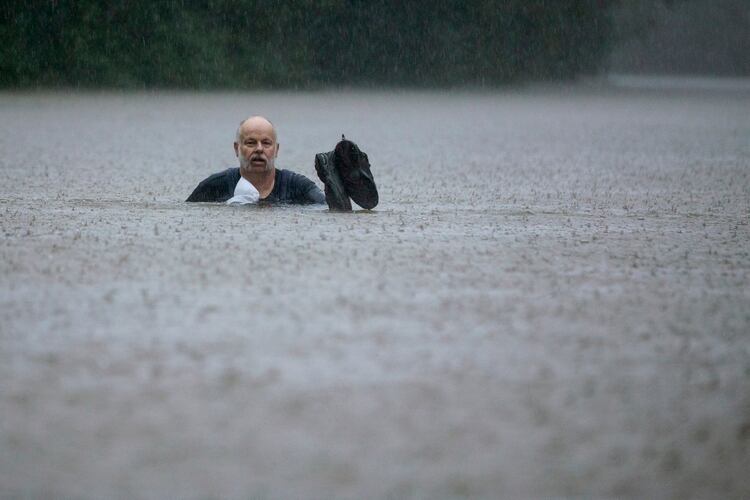 Un hombre camina en una zona inundada por las fuertes lluvias provocadas por la tormenta tropical Imelda el jueves 19 de septiembre de 2019 en Patton Village, Texas. (Brett Coomer/Houston Chronicle vía AP)