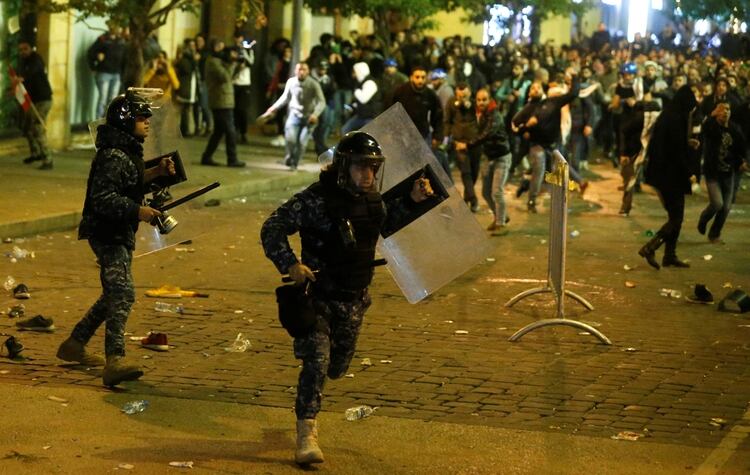 Policías antidisturbios libaneses corren para ponerse a cubierto en medio de las protestas en Beirut (REUTERS/Mohamed Azakir)