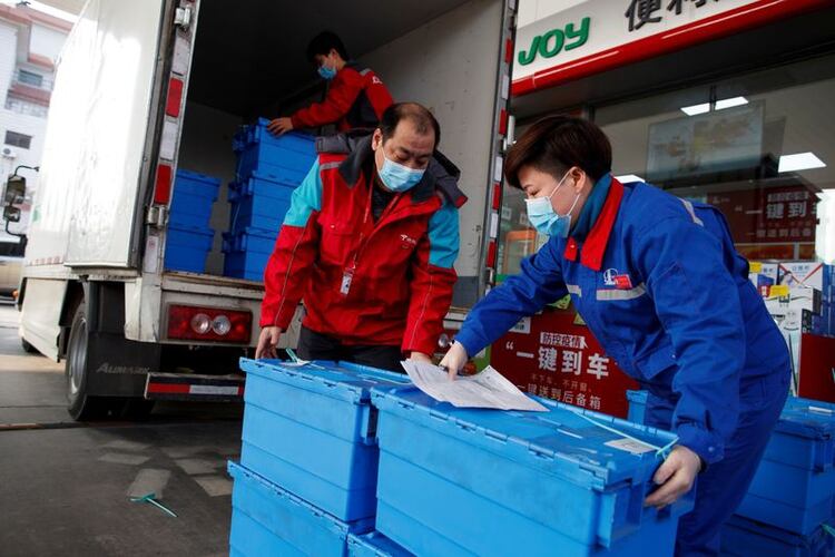 Trabajadores descargan mercancías en una estación de servicio de Sinopec, mientras el país se ve afectado por un brote del nuevo coronavirus, en Pekín, China. 28 de febrero de 2020. REUTERS/Thomas Peter.