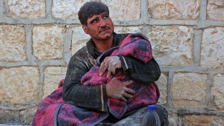 El hombre sostiene el cuerpo de su hija (Photo by Anas AL-DYAB / AFP)