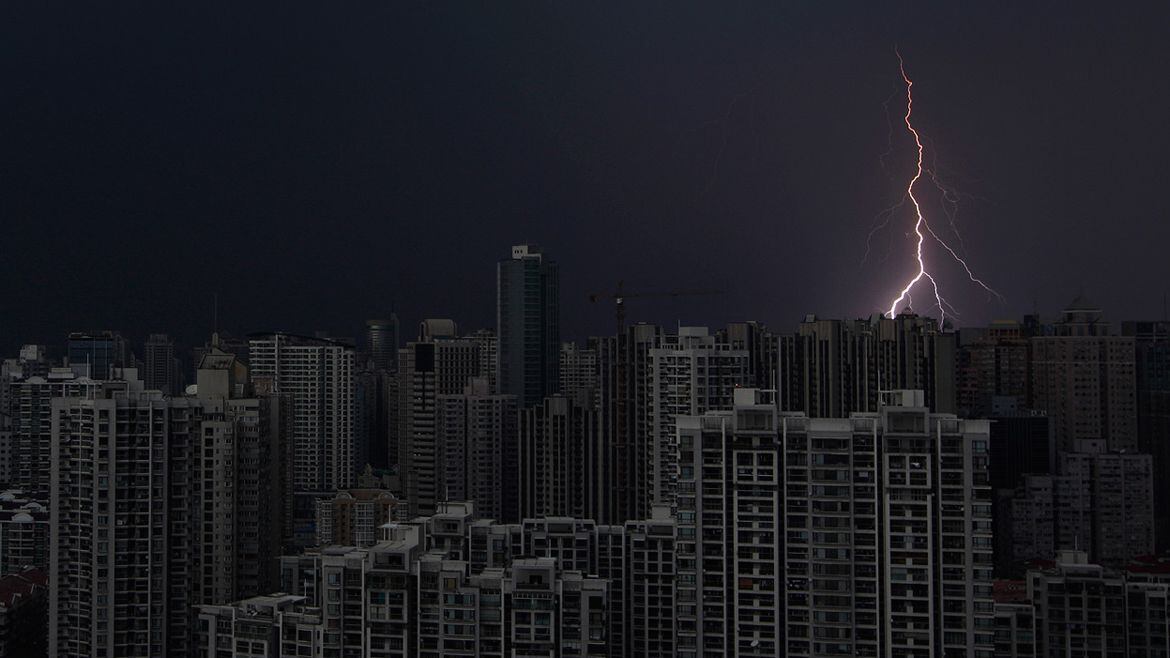 Un rayo atraviesa el cielo oscuro por encima de los edificios en el centro de Shanghai durante una tormenta ( Reuters)