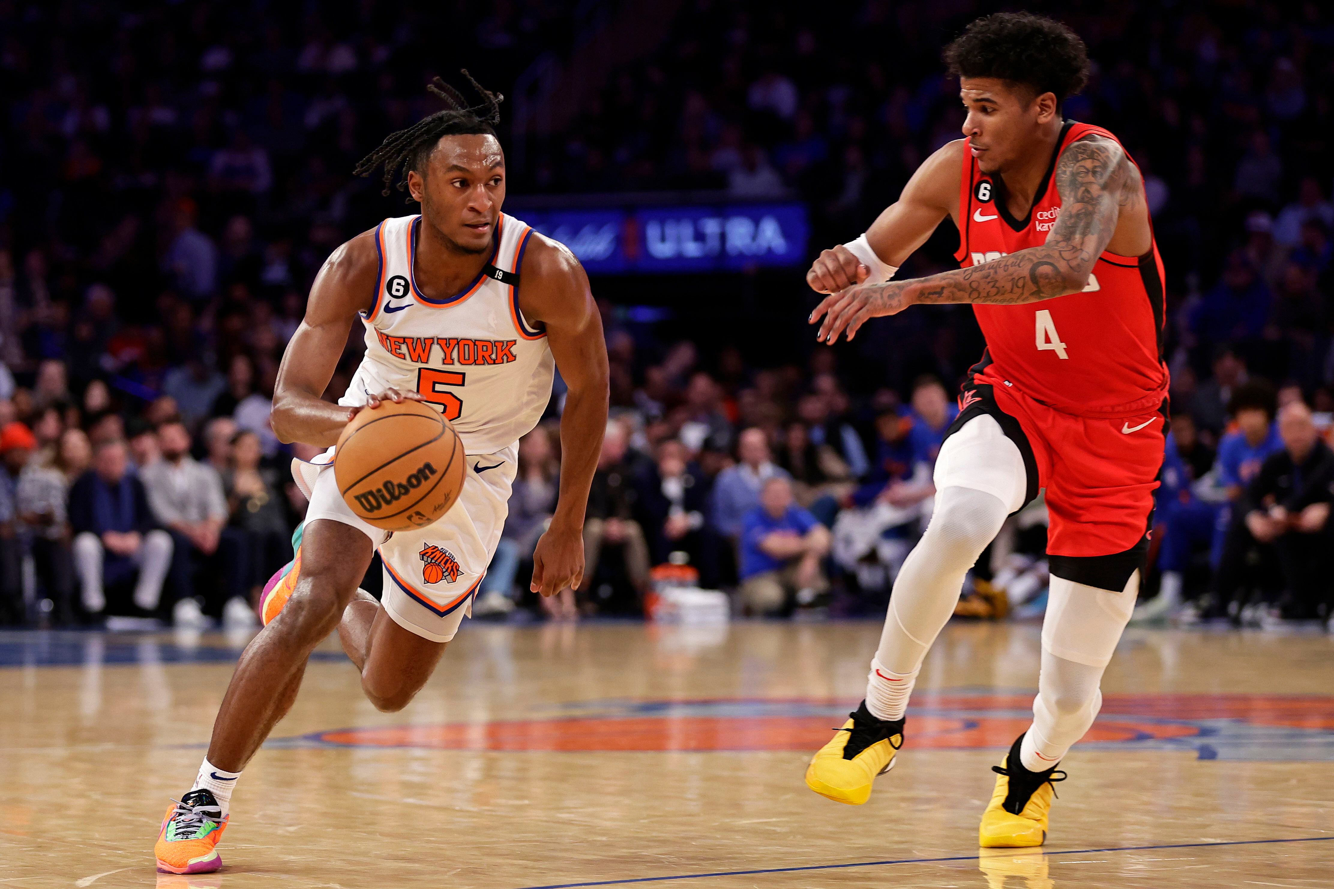 El base de los Knicks de Nueva York Immanuel Quickley avanza hacia la canasta superando al base de los Rockets de Houston Jalen Green en el encuentro del lunes 27 de marzo del 2023. (AP Foto/Adam Hunger)