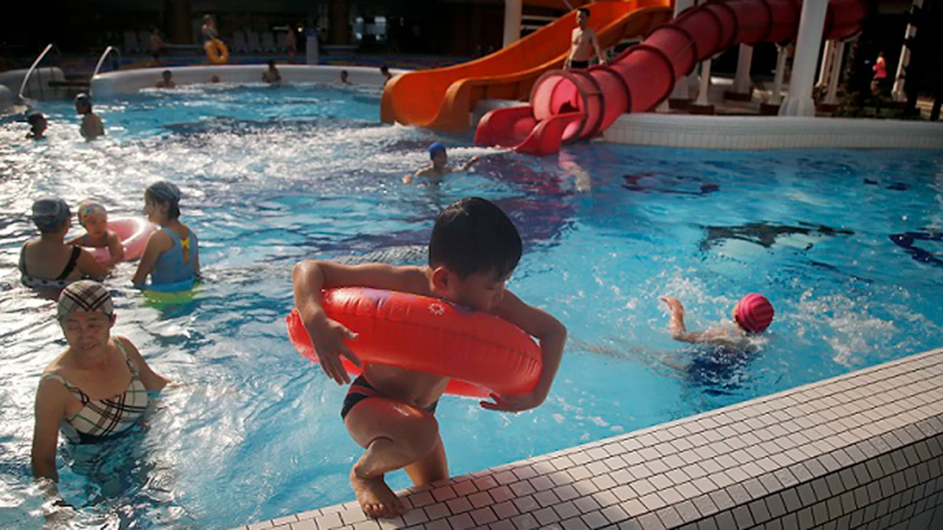Un niño saliendo de la piscina de la parte interior del parque acuático Munsu, abierto para locales y extranjeros (AP)