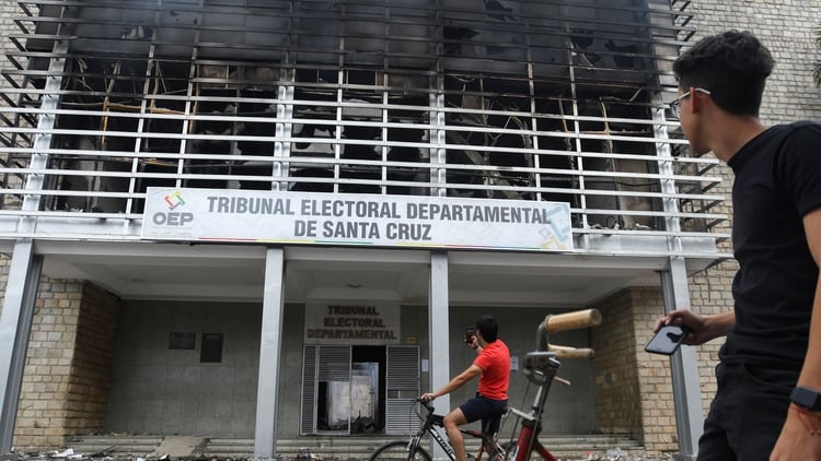 Residentes toman fotos del edificio del Tribunal Electoral de Santa Cruz, que fue incendiado por manifestantes durante una protesta, en Santa Cruz, Bolivia, el 23 de octubre de 2019 (REUTERS/Rodrigo Urzagasti)