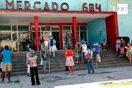 Varias personas esperan para entrar en un mercado a comprar productos, en La Habana (EFE/ Ernesto Mastrascusa)
