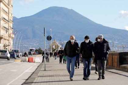 People wearing face masks walk the street, amid the outbreak of the coronavirus disease (COVID-19), in Naples, Italy, January 26, 2021. REUTERS/Ciro De Luca