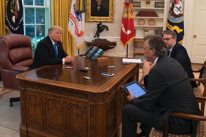 Trump en el salón Oval junto al botón rojo al lado de los teléfonos 