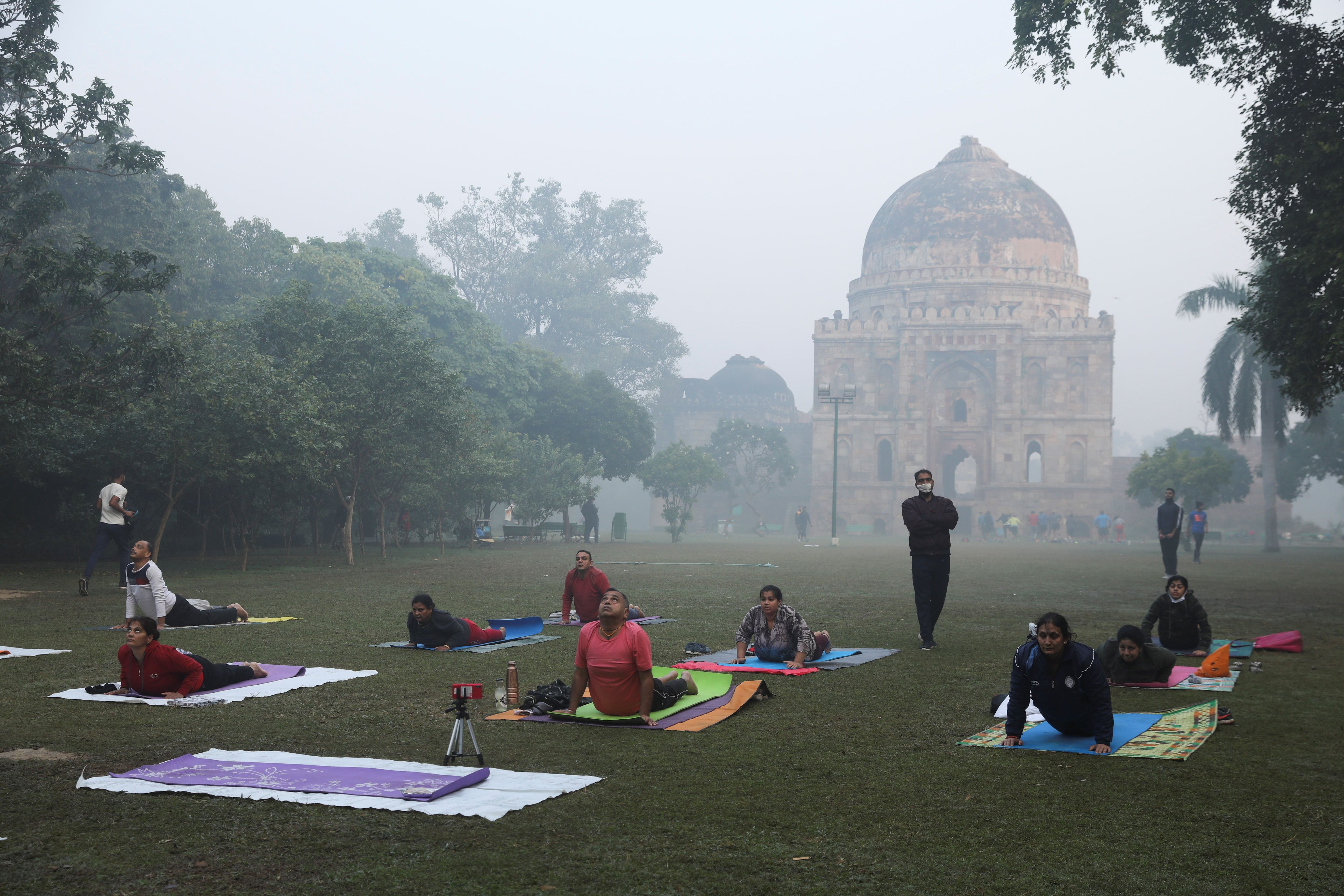 People exercise on a smoggy morning at Lodhi Garden in New Delhi, India, November 16, 2021. REUTERS / Anushree Fadnavis