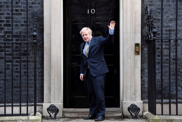 El primer ministro británico Boris Johnson saluda cuando llega a Downing Street 10 después de reunirse con la Reina en el Palacio de Buckingham para pedir permiso para formar gobierno (REUTERS/Toby Melville)