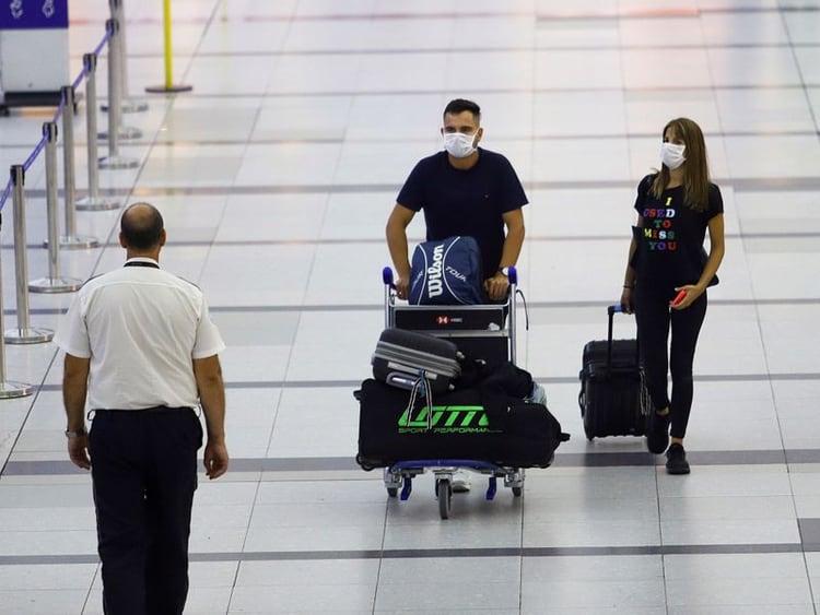 Pasajeros con mascarillas caminan en el Aeropuerto Internacional Ministro Pistarini, en Buenos Aires (Foto: Reuters)