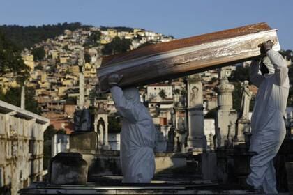 Sepultureros llevan el ataÃºd de Antonia Rodrigues durante su funeral tras fallecer por la enfermedad respiratoria COVID-19, en RÃ­o de Janeiro, Brasil, Mayo 18, 2020.  REUTERS/Ricardo Moraes