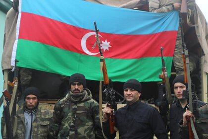 Los miembros del servicio azeríes sostienen armas mientras posan para una fotografía en el asentamiento de Suqovushan, que quedó bajo el control de las tropas de Azerbaiyán luego de un conflicto militar en Nagorno-Karabaj contra las fuerzas de etnia armenia y una nueva firma de un acuerdo de alto el fuego, en el distrito de Tartar, diciembre 6, 2020. Fotografía tomada el 6 de diciembre de 2020. REUTERS / Aziz Karimov
